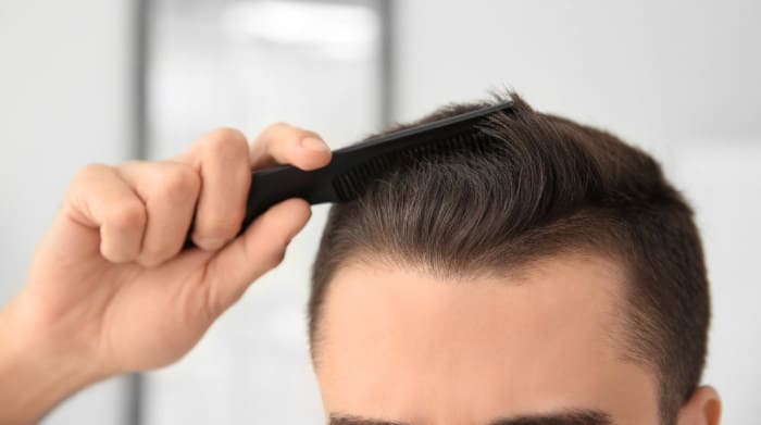 Haarstruktur Veraenderung - Junge Mann kämmt seine Haare