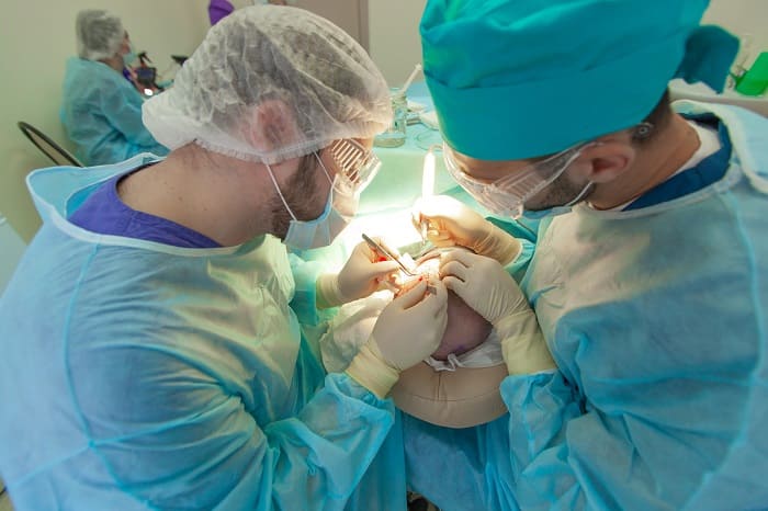 Zwei Ärzte führen eine Haartransplantation durch.